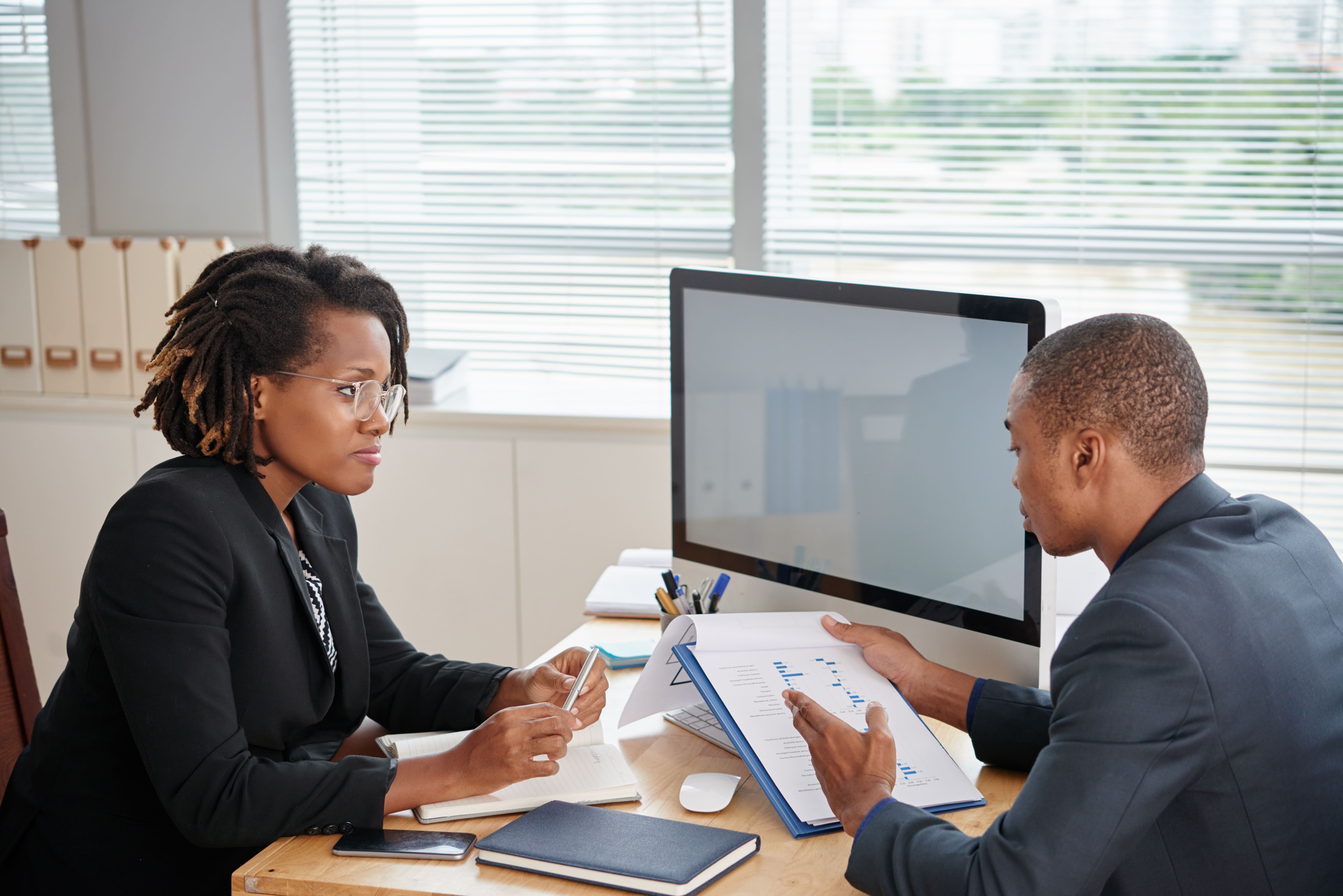 afro-american-man-suit-holding-documents-talking-female-boss